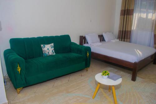 a living room with a green couch and a bed at Classic Studio Bamburi in Mombasa