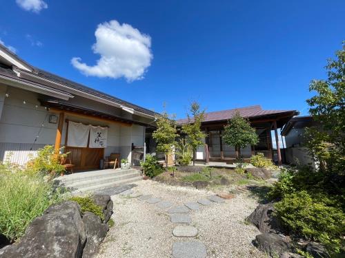 a house with a stone walkway in front of it at 笠神庵 in Tagajo