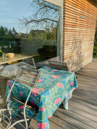 a patio with a table and a chair on a deck at Natural Wooden House With Panoramic View in Ihlow