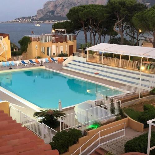a large swimming pool with a view of the ocean at Finestra sul Golfo in Mondello