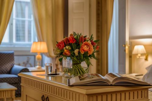 a table with a book and a vase of flowers at Palazzo Guicciardini in Florence