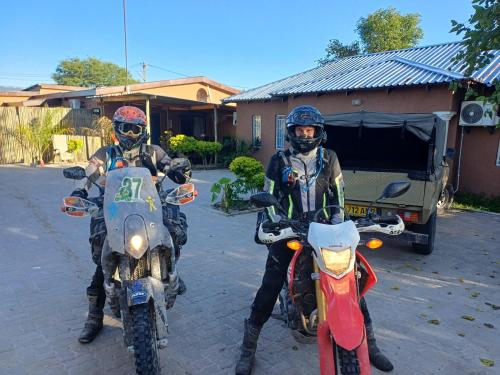 two people on motorcycles parked in front of a house at Jayla Homestay in Maun