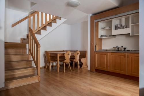 a kitchen and dining room with a table and stairs at Hotel Residence 3 Signori in Santa Caterina Valfurva