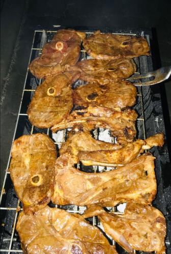 a bunch of food cooking on a grill at Jayla Homestay in Maun