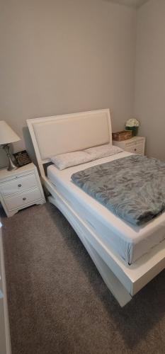 a bedroom with a white bed and two night stands at Lake Cypress Villa in Hot Wells