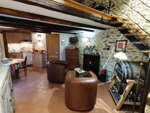 a kitchen and living room with a stone wall at La petite porcherie in Ladignac-le-Long