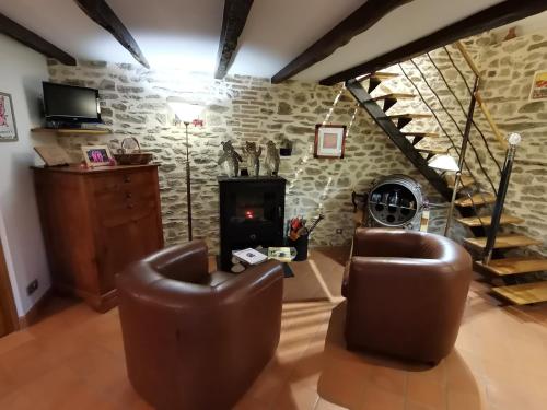 a living room with two chairs and a fireplace at La petite porcherie in Ladignac-le-Long