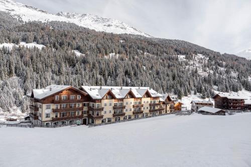 a large building with snow on it in front of a mountain at Hotel Residence 3 Signori in Santa Caterina Valfurva