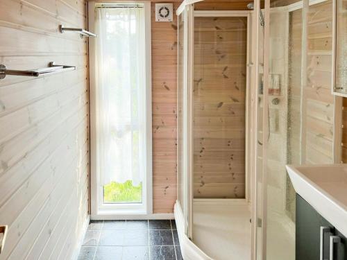 a bathroom with a walk in shower next to a window at Family Cabin With Panoramic Windows By Oksrødkilen in Gressvik
