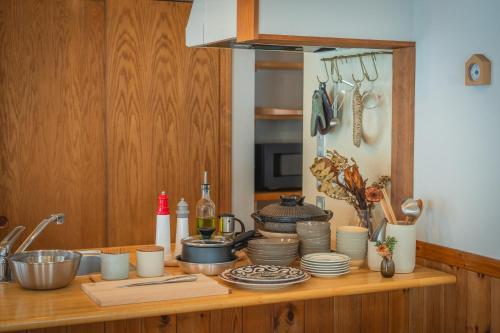 a kitchen counter with a bunch of dishes on it at LAMP Nojiriko The Sauna by the Lake in Shinano