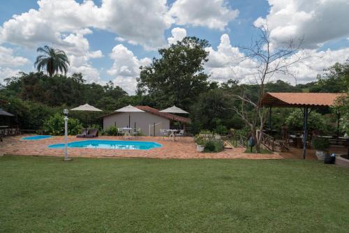 un patio con piscina y una casa en Estância das Angolas - Inhotim, en Brumadinho