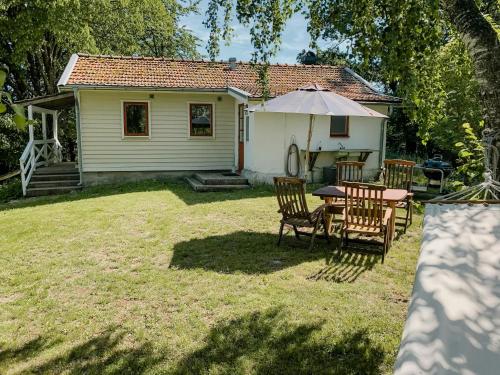 una pequeña casa con una mesa y sillas en el patio en Delight For The Soul In Österlen's Nature, en Gärsnäs