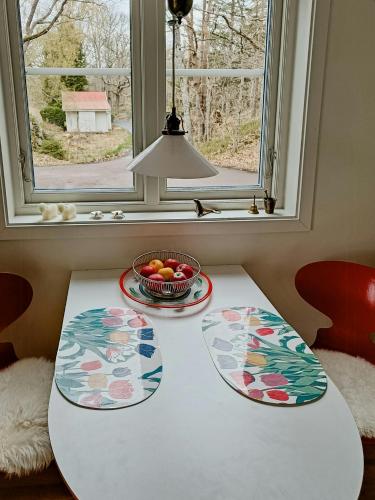 a table with a bowl of fruit and a window at Charming House Next To Forest And Sea in Kullavik