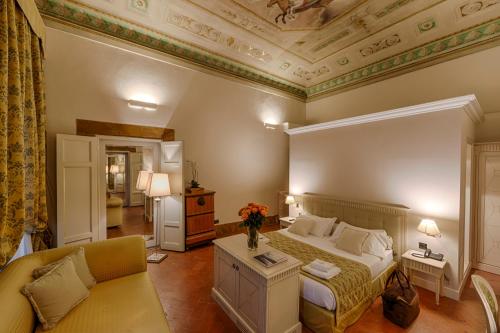 a bedroom with a king sized bed and a couch at Palazzo Guicciardini in Florence