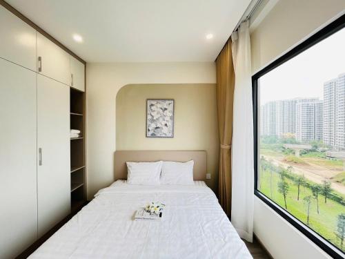 une chambre avec un lit et une grande fenêtre dans l'établissement May Homes - 3PN BS8 Tropiacal Vinhomes Grand Park, à Long Bình