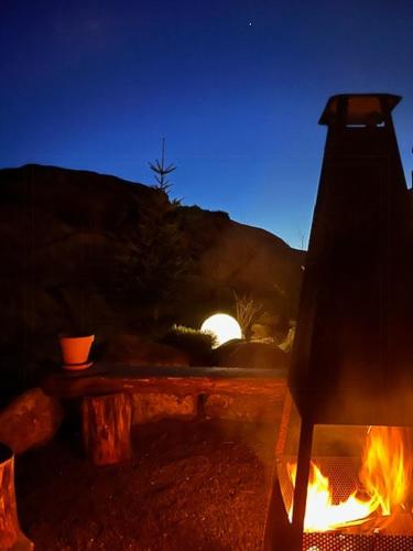a fire pit with a table and a fire at Scenic Cabin With Panoramic Views In Jæren in Sirevåg