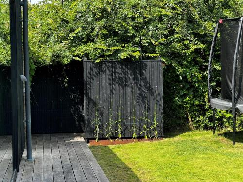a black gate in a yard with grass at Modern Exclusivity In 60S House Near Dyngby Beach in Odder