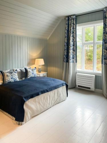 a bedroom with a large bed and a window at Charming Swiss-Style Cabin On Hankø in Gressvik