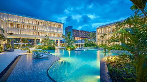 a hotel with a pool in front of a building at Holiday Inn Resort Bintan Lagoi Beach by IHG in Lagoi