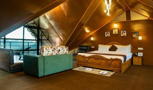 a bedroom with a bed and a chair in a room at Mount Queens Hill Resort & Spa in Mirik