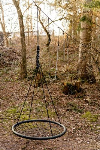 a swing set in the middle of a forest at Cozy Times In Log House Amongst Trees in Ebeltoft