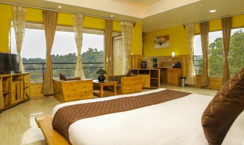 a bedroom with a large bed and a large window at Mount Queens Hill Resort & Spa in Mirik