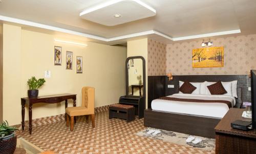 a hotel room with a bed and a desk at Mount Queens Hill Resort & Spa in Mirik