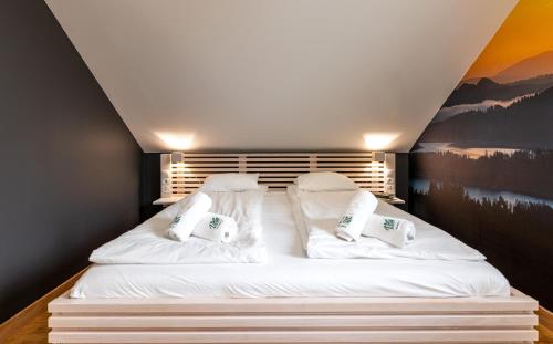 a bed with white sheets and pillows in a room at Vela Polańczyk Rodzinne Domki Nad Jeziorem in Polańczyk