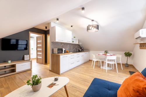 a living room with a kitchen and a table at Vela Polańczyk Rodzinne Domki Nad Jeziorem in Polańczyk