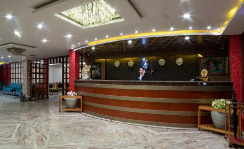 a lobby with a bar with a person standing behind it at Mount Queens Hill Resort & Spa in Mirik