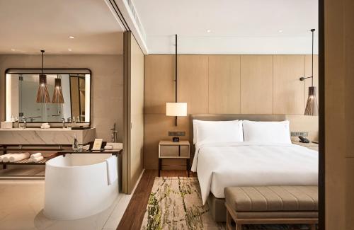 a hotel room with a bed and a bathtub at Holiday Inn Resort Bintan Lagoi Beach by IHG in Lagoi