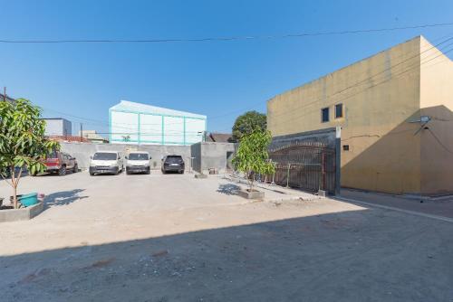 a parking lot with cars parked next to a building at Urbanview Aurel House Cirebon in Plered