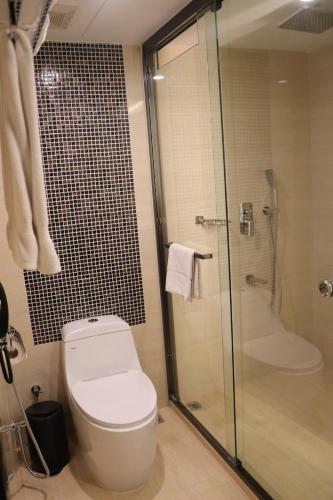 a bathroom with a toilet and a glass shower at Grand Sylhet Hotel & Resort in Sylhet