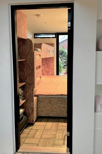 an open door of a tiny house with a bed at Modern Exclusivity In 60S House Near Dyngby Beach in Odder