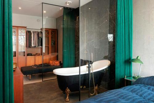 a bathroom with a bath tub and a bedroom at Hotel Vibe In Architectural Settings in Årre