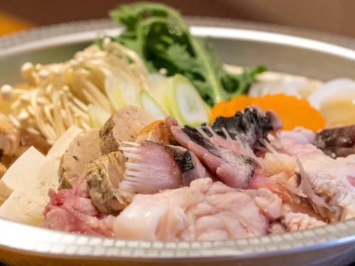 a bowl of food with meat and vegetables on a table at Hakuba Alps Hotel in Otari