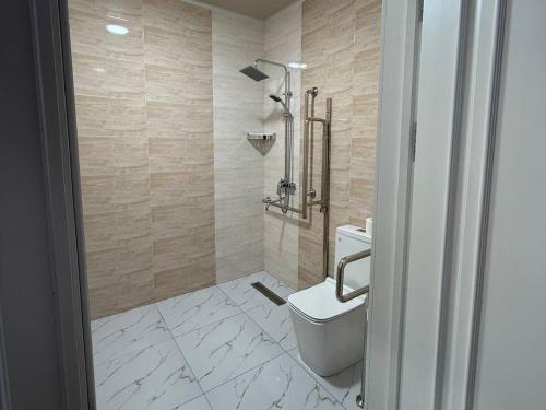 a bathroom with a toilet and a shower at Reikartz Qarshi in Qarshi