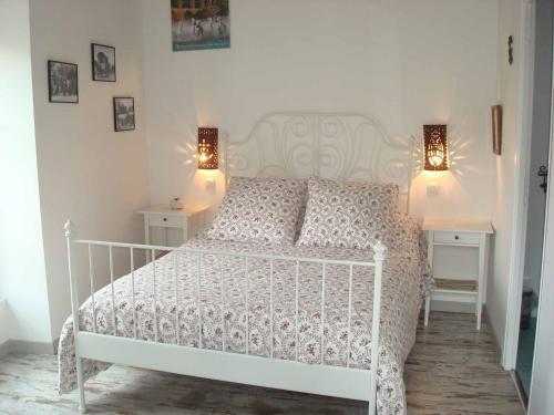 a white bed in a bedroom with two night stands at Chambres d'hôtes au Mas du Sire in Quissac