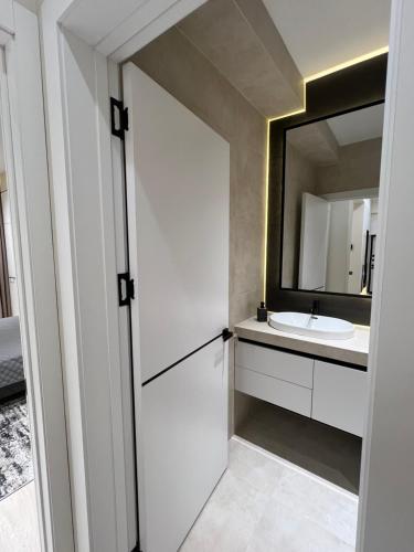 a bathroom with a white sink and a mirror at PA- premium apartments in Bukhara