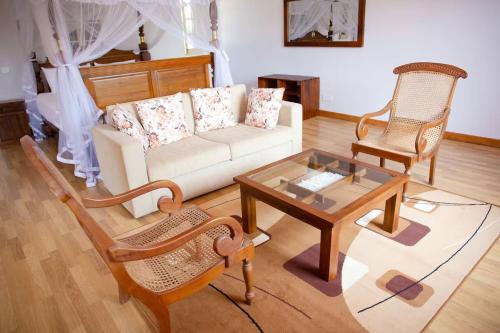 a living room with a couch and two chairs and a table at Adaaran Villa Bolgoda in Moratuwa
