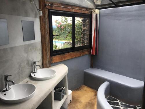 La salle de bains est pourvue de 2 lavabos, d'une baignoire et d'une fenêtre. dans l'établissement Gîte de France à Altillac 4 épis - Gîte de France 8 personnes MAE-0731, à Altillac