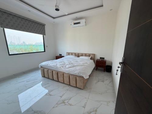 Un dormitorio blanco con una cama y una ventana. en Dhaulidhar Farms, en Greater Noida