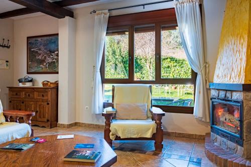 a living room with a chair and a fireplace at Casa Rural Arroal I in Sotoserrano
