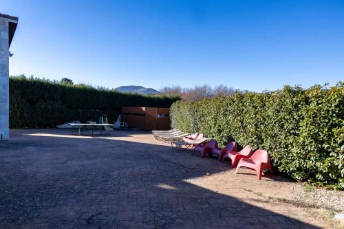 a row of park benches sitting next to a hedge at El Arrebol Rural in El Espinar
