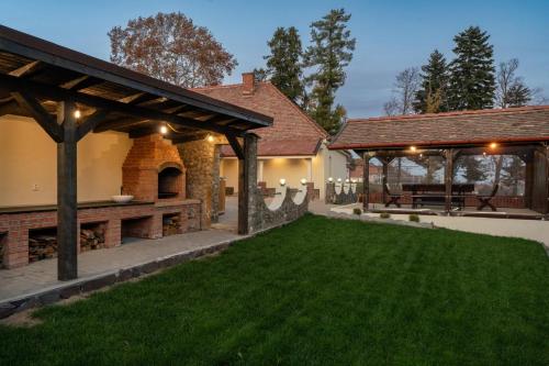 an estate with a patio and a grass yard at Vila Luiza in Cisnadioara