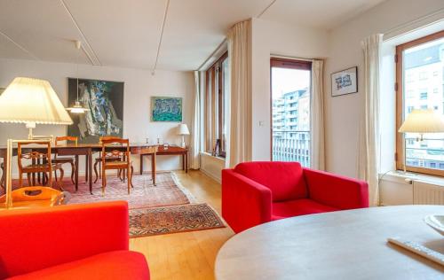 a living room with red chairs and a table at Spacious Canal-View Apartment Near Metro in Christianshavn in Copenhagen