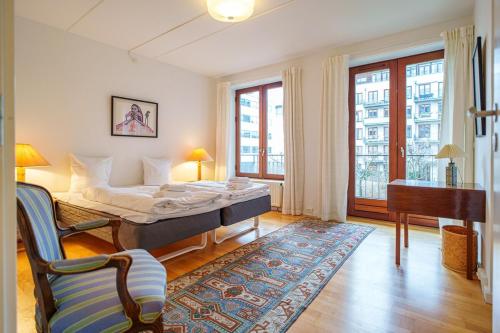 a bedroom with a bed and a couch and a piano at Spacious Canal-View Apartment Near Metro in Christianshavn in Copenhagen