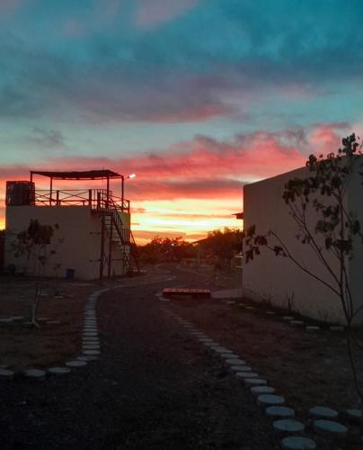 a sunset behind a building with a scaffolding at Tres Velas Surf in Celestino Gasca
