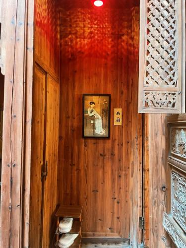 a room with a wooden wall with a picture on it at Standing in the wild in Xiwu