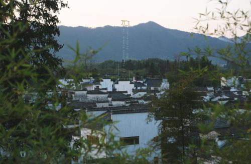 a view of a town with a mountain in the background at Standing in the wild in Xiwu